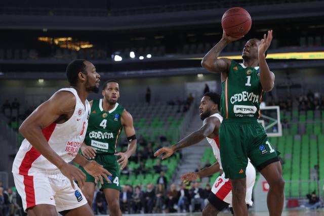(251217) -- LJUBLJANA, Dec. 17, 2025 (Xinhua) -- Umoja Gibson (1st R) of Cedevita Olimpija Ljubljana shoots during the BKT EuroCup 2025/26 11th round basketball match between Cedevita Olimpija Ljubljana and Hapoel Midtown Jerusalem in Ljubljana, Slovenia, on Dec. 16, 2025. (Photo by Zeljko Stevanic/Xinhua)