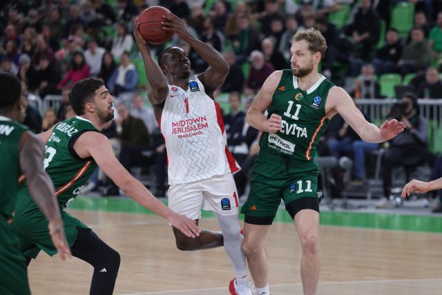 (251217) -- LJUBLJANA, Dec. 17, 2025 (Xinhua) -- Jared Harper (2nd R) of Hapoel Midtown Jerusalem competes during the BKT EuroCup 2025/26 11th round basketball match between Cedevita Olimpija Ljubljana and Hapoel Midtown Jerusalem in Ljubljana, Slovenia, on Dec. 16, 2025. (Photo by Zeljko Stevanic/Xinhua)