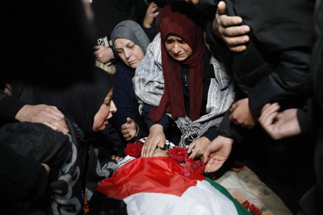 (251217) -- BETHLEHEM, Dec. 17, 2025 (Xinhua) -- Mourners and relatives gather around the body of Palestinian boy Ammar Ta'amra, who was shot dead by Israeli army, during his funeral in the town of Tuqu', southeast of Bethlehem in the West Bank, on Dec. 16, 2025. The 16-year-old Palestinian, Ammar Ta'amra, was shot dead, by the Israeli army during a military raid on Tuqu' on Monday, the Palestinian health ministry said. (Photo by Mamoun Wazwaz/Xinhua)