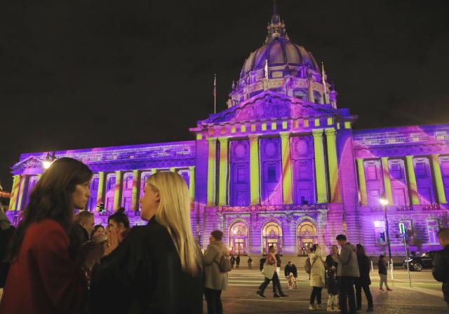 (251217) -- SAN FRANCISCO, Dec. 17, 2025 (Xinhua) -- People enjoy the "City Hall Winter Lights" show outside the City Hall in San Francisco, the United States, Dec. 16, 2025. (Photo by Liu Yilin/Xinhua)