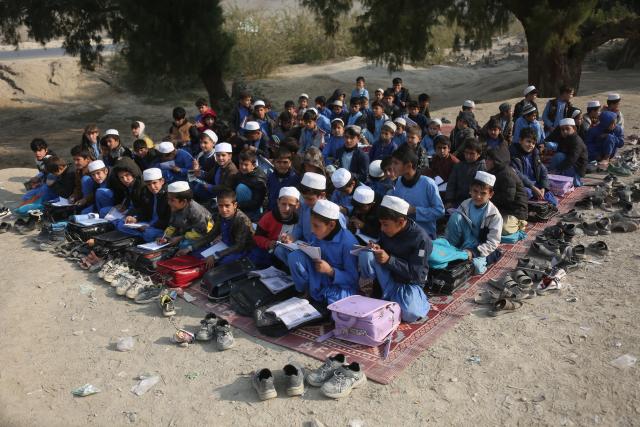 (251217) -- NANGARHAR, Dec. 17, 2025 (Xinhua) -- Students attend an outdoor class at a makeshift roadside school without proper shelters beside a highway junction in Nangarhar province, eastern Afghanistan, Dec. 16, 2025. (Photo by Saifurahman Safi/Xinhua)