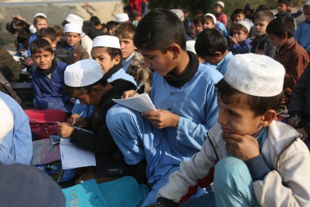 (251217) -- NANGARHAR, Dec. 17, 2025 (Xinhua) -- Students attend an outdoor class at a makeshift roadside school without proper shelters beside a highway junction in Nangarhar province, eastern Afghanistan, Dec. 16, 2025. (Photo by Saifurahman Safi/Xinhua)