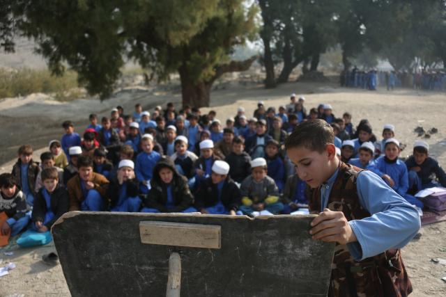 (251217) -- NANGARHAR, Dec. 17, 2025 (Xinhua) -- Students attend an outdoor class at a makeshift roadside school without proper shelters beside a highway junction in Nangarhar province, eastern Afghanistan, Dec. 16, 2025. (Photo by Saifurahman Safi/Xinhua)