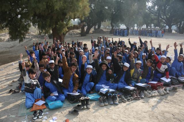 (251217) -- NANGARHAR, Dec. 17, 2025 (Xinhua) -- Students take a class in the open air at a makeshift roadside school without proper shelters beside a highway junction in Nangarhar province, eastern Afghanistan, Dec. 16, 2025. (Photo by Saifurahman Safi/Xinhua)