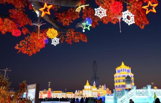(251217) -- HARBIN, Dec. 17, 2025 (Xinhua) -- Tourists visit the Harbin Ice-Snow World in Harbin, northeast China's Heilongjiang Province, Dec. 17, 2025. The Harbin Ice-Snow World, world's largest ice and snow theme park, officially opened for the season on Wednesday, unveiling its most spectacular edition yet, featuring landmark attractions, thoughtful services and magnificent ice sculptures across a record 1.2 million square meters of park area. (Xinhua/Wang Jianwei)