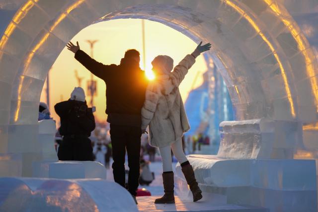 (251217) -- HARBIN, Dec. 17, 2025 (Xinhua) -- Tourists take photos at the Harbin Ice-Snow World in Harbin, northeast China's Heilongjiang Province, Dec. 17, 2025. The Harbin Ice-Snow World, world's largest ice and snow theme park, officially opened for the season on Wednesday, unveiling its most spectacular edition yet, featuring landmark attractions, thoughtful services and magnificent ice sculptures across a record 1.2 million square meters of park area. (Xinhua/Wang Jianwei)