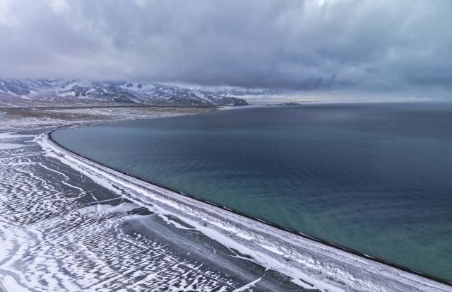 (251217) -- URUMQI, Dec. 17, 2025 (Xinhua) -- An aerial drone photo taken on Dec. 16, 2025 shows the Sayram Lake and snow mountain in Bortala Mongolian Autonomous Prefecture, northwest China's Xinjiang Uygur Autonomous Region. (Photo by Xu Rui/Xinhua)
