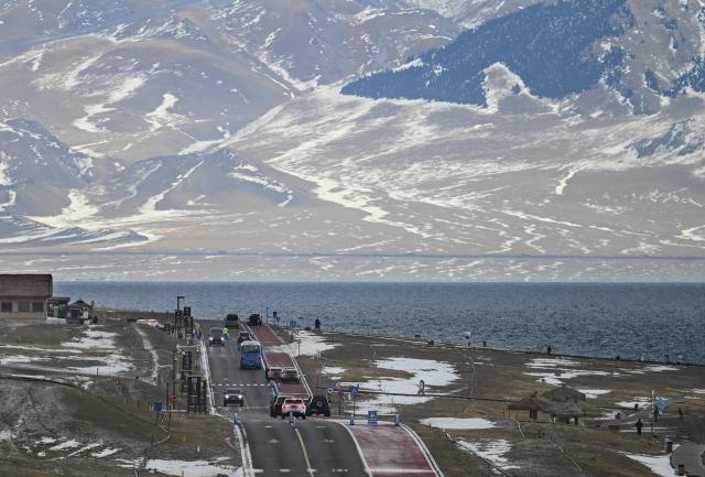 (251217) -- URUMQI, Dec. 17, 2025 (Xinhua) -- Tourists are seen by the Sayram Lake in Bortala Mongolian Autonomous Prefecture, northwest China's Xinjiang Uygur Autonomous Region, Dec. 15, 2025. (Photo by Xu Rui/Xinhua)
