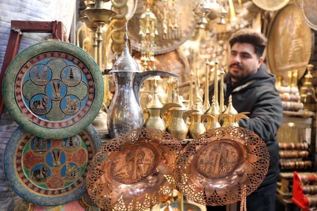 (251217) -- BAGHDAD, Dec. 17, 2025 (Xinhua) -- A shop owner sells copper artifacts in Safafeer copper market in Baghdad, Iraq, Dec.17, 2025. (Xinhua/Khalil Dawood)