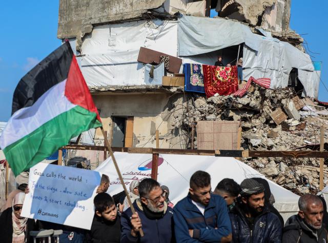 (251217) -- GAZA, Dec. 17, 2025 (Xinhua) -- Palestinians in the Al-Shati refugee camp west of Gaza City hold signs and chant slogans demanding the provision of temporary housing as the winter weather continues to hit the region, Dec. 17, 2025. (Photo by Rizek Abdeljawad/Xinhua)
