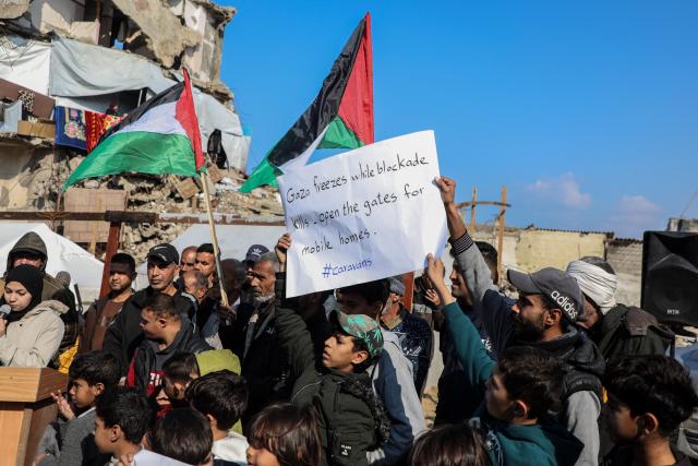 (251217) -- GAZA, Dec. 17, 2025 (Xinhua) -- Palestinians in the Al-Shati refugee camp west of Gaza City hold signs and chant slogans demanding the provision of temporary housing as the winter weather continues to hit the region, Dec. 17, 2025. (Photo by Rizek Abdeljawad/Xinhua)