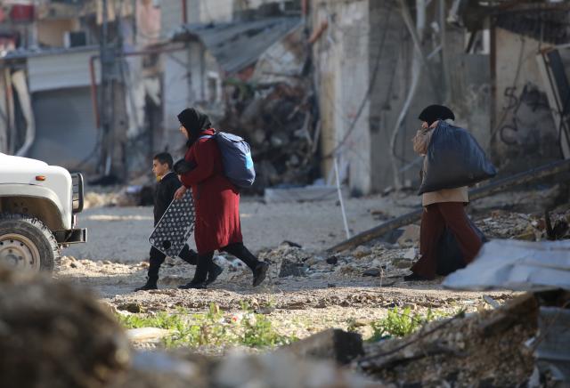 (251217) -- TULKARM, Dec. 17, 2025 (Xinhua) -- Palestinians carry their belongings in the Nur Shams refugee camp, east of Tulkarm in the West Bank, on Dec. 17, 2025. Previously the Israeli army announced the demolition of 25 homes in the Nur Shams refugee camp and allowed the homeowners to enter their homes and move their furniture and belongings on Wednesday morning. (Photo by Nidal Eshtayeh/Xinhua)