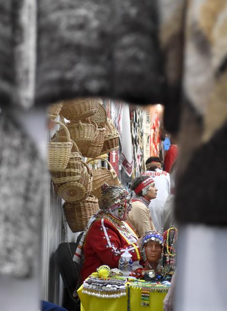 (251217) -- MOSCOW, Dec. 17, 2025 (Xinhua)-- A woman wearing traditional clothes is reflected in a mirror at the "Ladya" exhibition and fair of Russian folk arts and crafts in Moscow, Russia, Dec. 17, 2025. The exhibition is held from December 17-21 this year. (Photo by Alexander Zemlianichenko Jr/Xinhua)