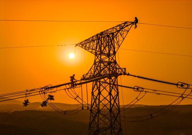 (251218) -- BEIJING, Dec. 18, 2025 (Xinhua) -- A drone photo taken on Dec. 16, 2025 shows constructors working on a power transmission line in east China's Anhui Province. (Photo by Zheng Xianlie/Xinhua)