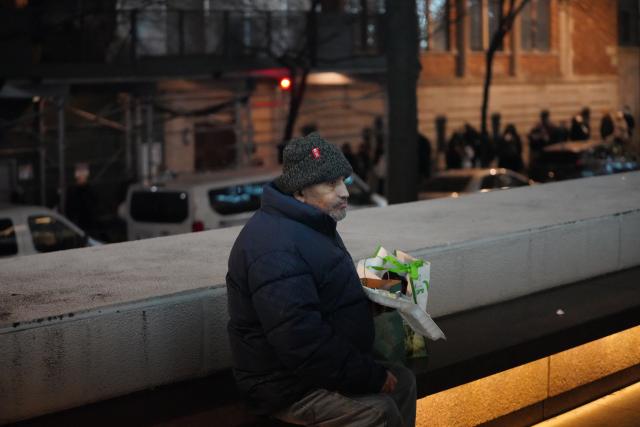 (251218) -- NEW YORK, Dec. 18, 2025 (Xinhua) -- A man eats free food received from a shelter in New York City, the United States, Dec. 17, 2025. (Xinhua/Zhang Fengguo)