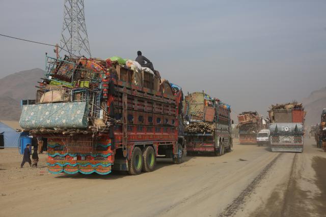 (251218) -- TORKHAM, Dec. 18, 2025 (Xinhua) -- Trucks bound for Afghan returnees' home provinces from a temporary camp are seen at the Torkham border crossing, Afghanistan, Dec. 16, 2025. As the world marks International Migrants Day on Thursday, the unfolding narrative in Afghanistan is one of resilience and uncertainty.
  The forced return of thousands from neighboring countries is reshaping lives: many families are coming back to a homeland they barely know, striving to rebuild amid fragile security and limited support. (Photo by Saifurahman Safi/Xinhua)