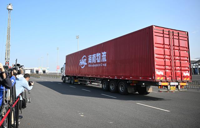 (251218) -- HAIKOU, Dec. 18, 2025 (Xinhua) -- A truck carrying the first batch of goods that completed customs clearance is pictured at a centralized inspection area in Xinhai Port and Nangang Port, two "second line" customs ports, in Haikou, south China's Hainan Province, Dec. 18, 2025. China on Thursday launched island-wide special customs operations in the Hainan Free Trade Port (FTP).
  The "first line" refers to Hainan's connection with overseas markets. Meanwhile, the "second line" refers to the customs boundary between Hainan and the mainland. (Xinhua/Pu Xiaoxu)