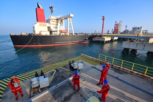 (251218) -- HAIKOU, Dec. 18, 2025 (Xinhua) -- Staff members tie a mooring rope for a vessel carrying petrochemical raw materials at Yangpu Port in Danzhou, south China's Hainan Province, Dec. 18, 2025. China on Thursday launched island-wide special customs operations in the Hainan Free Trade Port (FTP).
   A vessel carrying petrochemical raw materials arrived at Yangpu Port in the morning, marking the first batch of zero-tariff petrochemical raw materials to undergo special customs clearance there after the launch of the special customs operations. The goods amounted to 179,000 tonnes, with the total value of nearly 400 million yuan (about 56.8 million U.S. dollars). (Xinhua/Guo Cheng)