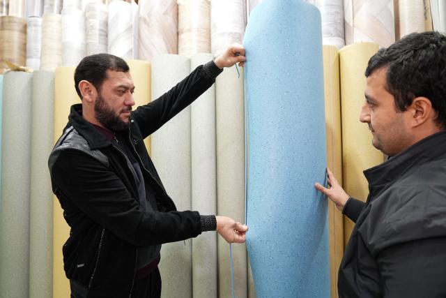 (251218) -- GUANGYUAN, Dec. 18, 2025 (Xinhua) -- Jamshid Tashpulatov (L), owner of a building supplies store, checks roll flooring materials from Guangyuan of southwest China's Sichuan Province, in Tashkent, Uzbekistan, Dec. 12, 2025. The home furnishing industry of Guangyuan stands out for its high quality, and its roll flooring products sell well across China and overseas.  
  In Tashkent, the capital of Uzbekistan, a building supplies store that sells flooring products from Guangyuan is doing brisk business. Jamshid Tashpulatov, the owner of the store, hopes to cooperate with more Chinese companies as the business keeps growing.
  Historically a key stop connecting China with other countries, Guangyuan is now emerging as a new landmark for western China's opening up. (Photo by Zafar Khalilov/Xinhua)
