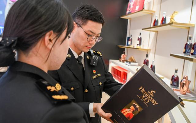 (251218) -- HAIKOU, Dec. 18, 2025 (Xinhua) -- Customs officers perform in-shop checks at Haikou International Duty Free Shopping Complex in Haikou, south China's Hainan Province, Dec. 18, 2025. China on Thursday launched island-wide special customs operations in the Hainan Free Trade Port (FTP). (Xinhua/Yang Guanyu)