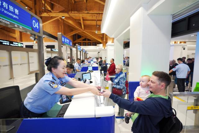 (251218) -- HAIKOU, Dec. 18, 2025 (Xinhua) -- An immigration officer processes border procedures for inbound passengers at Sanya Phoenix International Airport in Sanya, south China's Hainan Province, Dec. 18, 2025. China on Thursday launched island-wide special customs operations in the Hainan Free Trade Port (FTP). (Photo by Meng Xushun/Xinhua)