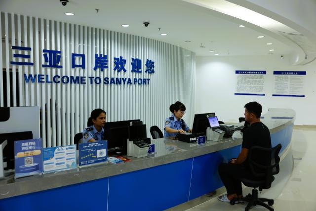 (251218) -- HAIKOU, Dec. 18, 2025 (Xinhua) -- Officers process border procedures for a crew member of a ship in Sanya, south China's Hainan Province, Dec. 18, 2025. China on Thursday launched island-wide special customs operations in the Hainan Free Trade Port (FTP). (Photo by Cong Gao/Xinhua)