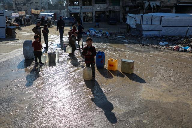(251218) -- GAZA CITY, Dec. 18, 2025 (Xinhua) -- Palestinian children transport water with containers in Gaza City, Dec. 18, 2025. (Photo by Rizek Abdeljawad/Xinhua)