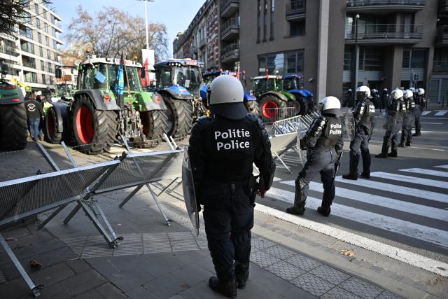 (251218) -- BRUSSELS, Dec. 18, 2025 (Xinhua) -- Police officers secure a road as farmers park tractors during a protest near the Europa Building in Brussels, Belgium, Dec. 18, 2025. Thousands of farmers from across Europe rallied near the European Parliament and the Europa Building in Brussels on Thursday as European Union (EU) leaders convened for a summit, with a long-negotiated trade deal with the South American bloc Mercosur on the agenda. (Xinhua/Lyu You)