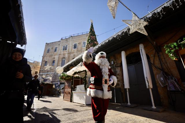 (251219) -- JERUSALEM, Dec. 19, 2025 (Xinhua) -- A man dressed as Santa Claus walks through a street adorned with Christmas decorations in Jerusalem on Dec. 18, 2025.
  The Christmas celebrations came amid a fragile ceasefire between Israel and Hamas following two years of conflict in the Gaza Strip. Scenes of holiday activities highlighted moments of relative calm and a desire for normalcy among local communities during the Christmas season. (Photo by Jamal Awad/Xinhua)