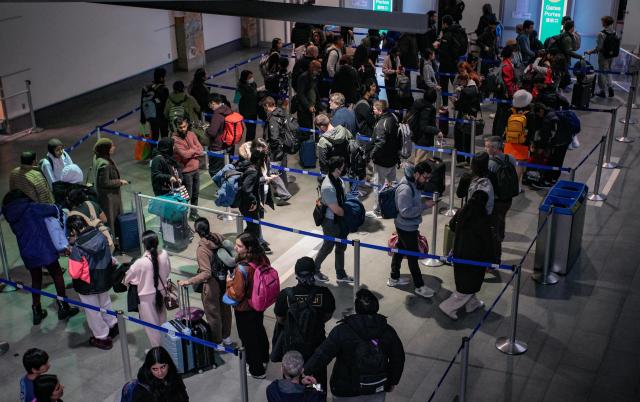 (251219) -- RICHMOND, Dec. 19, 2025 (Xinhua) -- Passengers wait in line at a security checkpoint at Vancouver International Airport in Richmond, British Columbia, Canada, Dec. 18, 2025. Winter holiday travel season has come, Vancouver International Airport handled more than 76,800 passenger trips on Thursday. (Photo by Liang Sen/Xinhua)