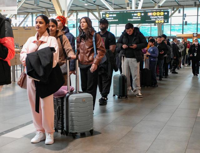 (251219) -- RICHMOND, Dec. 19, 2025 (Xinhua) -- Passengers wait in line at a security checkpoint at Vancouver International Airport in Richmond, British Columbia, Canada, Dec. 18, 2025. Winter holiday travel season has come, Vancouver International Airport handled more than 76,800 passenger trips on Thursday. (Photo by Liang Sen/Xinhua)