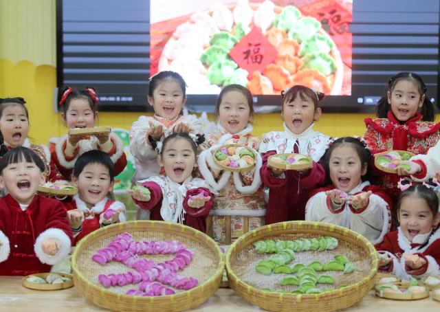 (251219) -- BEIJING, Dec. 19, 2025 (Xinhua) -- Children display dumplings they have just made at a kindergarten in Yangzhou City, east China's Jiangsu Province, Dec. 18, 2025. People all over the country held diverse events on Thursday to mark the Winter Solstice, which will fall on Dec. 21 this year.
   Winter Solstice, the shortest day of the year, denotes the beginning of deep winter and a break from farming in traditional agricultural society in Chinese culture. Northern China has maintained the tradition of eating dumplings on this day, while people in southern China eat tangyuan (glutinous rice balls). (Photo by Meng Delong/Xinhua)