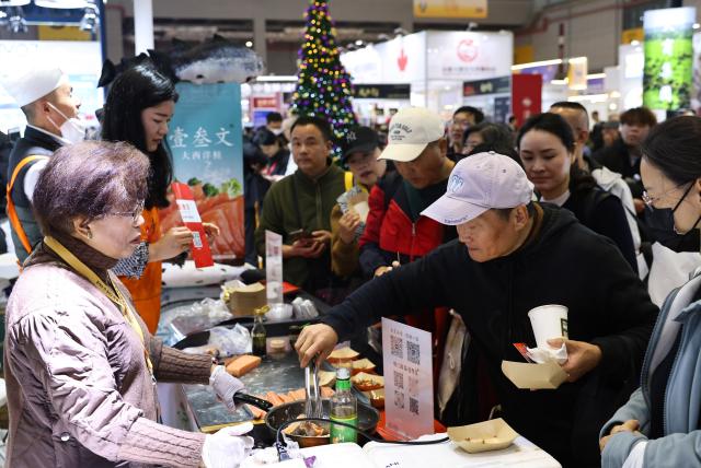 (251219) -- SHANGHAI, Dec. 19, 2025 (Xinhua) -- Visitors taste salmon from Chile at the CIIE U-Fair in the National Exhibition and Convention Center (Shanghai) in Shanghai, east China, Dec. 19, 2025.
  The CIIE U-Fair, an extension of the China International Import Expo (CIIE) for individual consumers, kicked off here on Friday.
  Dubbed a "mini CIIE", the U-Fair's offerings include food, home appliances, automobiles, beauty products, and health science products. (Xinhua/Fang Zhe)
