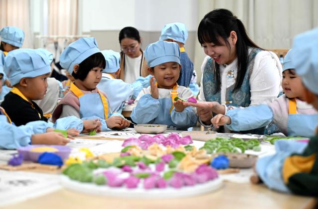 (251219) -- BEIJING, Dec. 19, 2025 (Xinhua) -- A teacher teaches children to make dumplings at a kindergarten in Xinhua District of Shijiazhuang City, north China's Hebei Province, Dec. 19, 2025. Winter Solstice, the shortest day of the year, which will fall on Dec. 21 this year, denotes the beginning of deep winter and a break from farming in traditional agricultural society in Chinese culture. 
   Northern China has maintained the tradition of eating dumplings on this day, while people in southern China eat tangyuan (glutinous rice balls). (Photo by Chen Qibao/Xinhua)