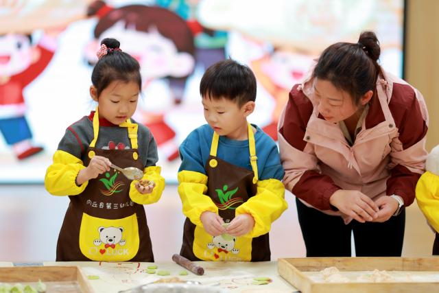 (251219) -- BEIJING, Dec. 19, 2025 (Xinhua) -- Children learn to make dumplings under the instruction of a teacher at a kindergarten in Neiqiu County of Xingtai City, north China's Hebei Province, Dec. 19, 2025. Winter Solstice, the shortest day of the year, which will fall on Dec. 21 this year, denotes the beginning of deep winter and a break from farming in traditional agricultural society in Chinese culture. 
   Northern China has maintained the tradition of eating dumplings on this day, while people in southern China eat tangyuan (glutinous rice balls). (Photo by Liu Jidong/Xinhua)