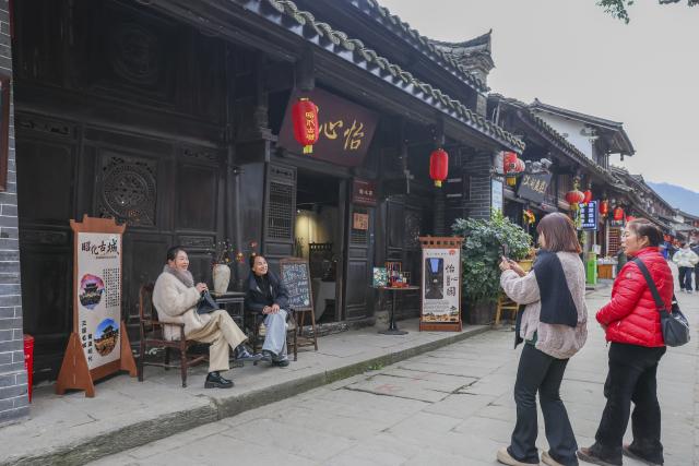 (251219) -- GUANGYUAN, Dec. 19, 2025 (Xinhua) -- Tourists pose for photos in Zhaohua ancient town in Zhaohua District of Guangyuan City, southwest China's Sichuan Province, Dec. 13, 2025. Zhaohua ancient town, located in Guangyuan City of southwest China's Sichuan Province, sits at the confluence of the Bailong River, the Jialing River, and the Qingjiang River. As a well-preserved ancient town, it carries a history of over 2,300 years.
    However, due to old infrastructure and unplanned construction, the ancient town once fell into disorder with residents living in the town having to undergo various difficulties. In order to refresh the ancient town, since 2012, Zhaohua District has launched a project to preserve the villages as a whole. While improving the village environment, the preservation project brings along local rural tourism, allowing the ancient town to be revitalized through preservation. (Xinhua/Wu Di)