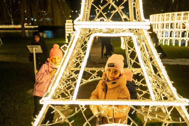 (251219) -- PRAGUE, Dec. 19, 2025 (Xinhua) -- Children play at the Story of Lights themed park in Prague, the Czech Republic, Dec. 19, 2025. An Europe-themed light park illuminates the banks of the Vltava River in Prague, offering visitors an immersive journey of architecture and light. (Photo by Dana Kesnerova/Xinhua)