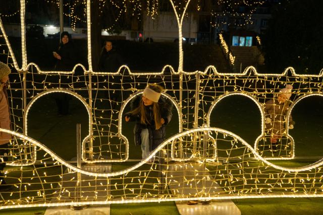 (251219) -- PRAGUE, Dec. 19, 2025 (Xinhua) -- People visit the Story of Lights themed park in Prague, the Czech Republic, Dec. 19, 2025. An Europe-themed light park illuminates the banks of the Vltava River in Prague, offering visitors an immersive journey of architecture and light. (Photo by Dana Kesnerova/Xinhua)