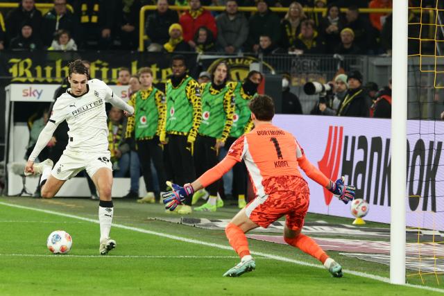 (251220) -- DORTMUND, Dec. 20, 2025 (Xinhua) -- Florian Neuhaus (L) of Borussia Moenchengladbach shoots during the German first division Bundesliga football match between Borussia Dortmund and Borussia Moenchengladbach in Dortmund, Germany, Dec. 19, 2025. (Photo by Joachim Bywaletz/Xinhua)