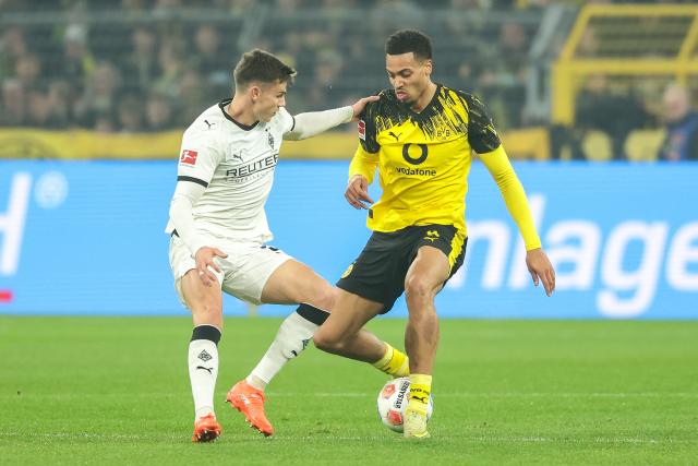 (251220) -- DORTMUND, Dec. 20, 2025 (Xinhua) -- Felix Nmecha (R) of Borussia Dortmund vies with Yannik Engelhardt of Borussia Moenchengladbach during the German first division Bundesliga football match between Borussia Dortmund and Borussia Moenchengladbach in Dortmund, Germany, Dec. 19, 2025. (Photo by Joachim Bywaletz/Xinhua)