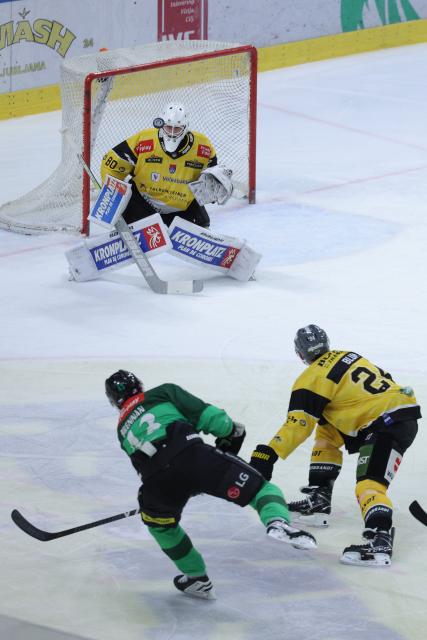 (251220) -- LJUBLJANA, Dec. 20, 2025 (Xinhua) -- Terrence James Brennan (L) of Olimpija LJubljana shoots during the 2025/26 Win2day Ice Hockey League match between Olimpija LJubljana and HC Falkensteiner Pustertal in Ljubljana, Slovenia, Dec. 19, 2025. (Photo by Zeljko Stevanic/Xinhua)