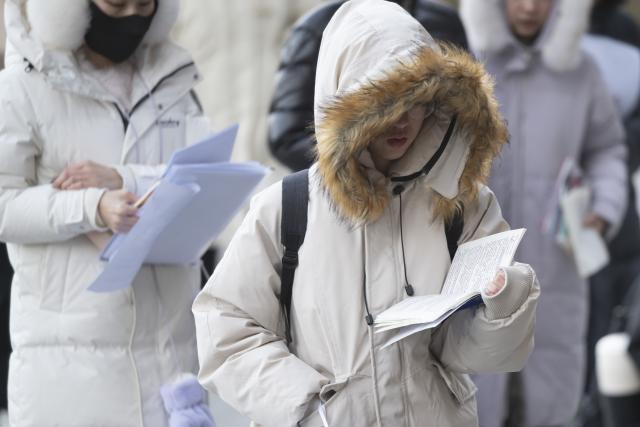 (251220) -- BEIJING, Dec. 20, 2025 (Xinhua) -- Examinees prepare to enter an examination site for the 2026 postgraduate entrance exam in Harbin, northeast China's Heilongjiang Province, Dec. 20, 2025. China's national exam for postgraduate enrolment kicked off on Saturday. (Xinhua/Zhang Tao)