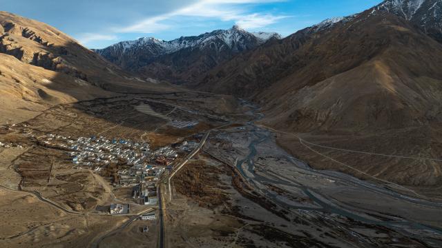 (251220) -- BURANG, Dec. 20, 2025 (Xinhua) -- An aerial drone photo taken on Dec. 18, 2025 shows a view of Khorchak Village in Burang County of Ngari Prefecture, southwest China's Xizang Autonomous Region.
  Two days ahead of the Tibetan New Year is the traditional "Gutu Eve" for families to have a feast of "gutu", a traditional soup dish made of flour, at home. "Gu" in Tibetan means nine, which is a lucky number. "Tu" means "pasta." Nine different fillings like wool, charcoal and chili are placed inside the dough drops, and each of these fillings has a meaning. While in Burang, "Gutu" is a sort of porridge with nine ingredients and also a distinctive dish on the dinner table of the "Gutu Eve."
   In Khorchak Village of Burang County, Jamyang Drolma's family is bustling with New Year preparations at home. A pot of "Gutu" steams on the stove, while the "chema," a two-tier rectangular wooden box containing roasted barley and fried wheat grain, is placed to pray for harvest in the next year. This year, the family rejoiced over a bumper harvest of highland barley and peas. "Life is getting better and better, and our New Year celebrations are becoming more lively each year," Jamyang Drolma said with a smile. (Xinhua/Tenzin Nyida)