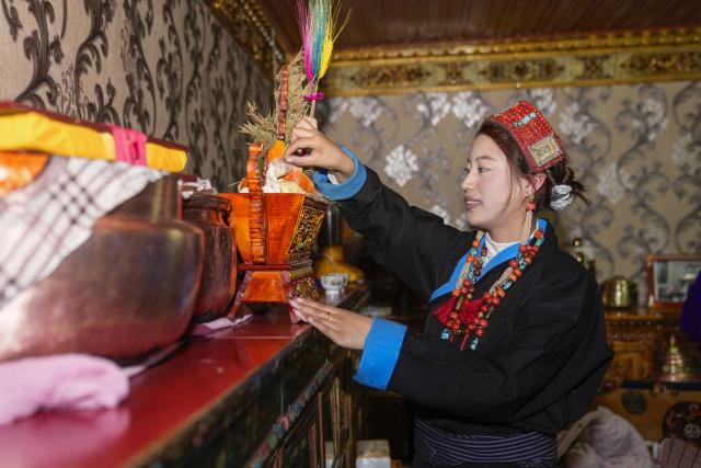 (251220) -- BURANG, Dec. 20, 2025 (Xinhua) -- Jamyang Drolma prepares "chema" at home in Khorchak Village, Burang County of Ngari Prefecture, southwest China's Xizang Autonomous Region, Dec. 18, 2025.
  Two days ahead of the Tibetan New Year is the traditional "Gutu Eve" for families to have a feast of "gutu", a traditional soup dish made of flour, at home. "Gu" in Tibetan means nine, which is a lucky number. "Tu" means "pasta." Nine different fillings like wool, charcoal and chili are placed inside the dough drops, and each of these fillings has a meaning. While in Burang, "Gutu" is a sort of porridge with nine ingredients and also a distinctive dish on the dinner table of the "Gutu Eve."
   In Khorchak Village of Burang County, Jamyang Drolma's family is bustling with New Year preparations at home. A pot of "Gutu" steams on the stove, while the "chema," a two-tier rectangular wooden box containing roasted barley and fried wheat grain, is placed to pray for harvest in the next year. This year, the family rejoiced over a bumper harvest of highland barley and peas. "Life is getting better and better, and our New Year celebrations are becoming more lively each year," Jamyang Drolma said with a smile. (Xinhua/Tenzin Nyida)