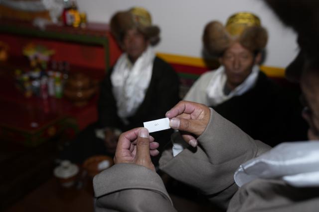 (251220) -- BURANG, Dec. 20, 2025 (Xinhua) -- A resident shows a note denoting wishes and expectations for the New Year on the "Gutu Eve" in Khorchak Village, Burang County of Ngari Prefecture, southwest China's Xizang Autonomous Region, Dec. 18, 2025.
  Two days ahead of the Tibetan New Year is the traditional "Gutu Eve" for families to have a feast of "gutu", a traditional soup dish made of flour, at home. "Gu" in Tibetan means nine, which is a lucky number. "Tu" means "pasta." Nine different fillings like wool, charcoal and chili are placed inside the dough drops, and each of these fillings has a meaning. While in Burang, "Gutu" is a sort of porridge with nine ingredients and also a distinctive dish on the dinner table of the "Gutu Eve."
   In Khorchak Village of Burang County, Jamyang Drolma's family is bustling with New Year preparations at home. A pot of "Gutu" steams on the stove, while the "chema," a two-tier rectangular wooden box containing roasted barley and fried wheat grain, is placed to pray for harvest in the next year. This year, the family rejoiced over a bumper harvest of highland barley and peas. "Life is getting better and better, and our New Year celebrations are becoming more lively each year," Jamyang Drolma said with a smile. (Xinhua/Tenzin Nyida)