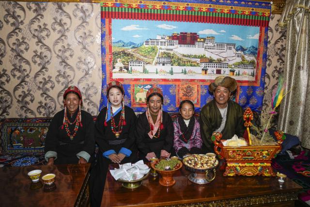 (251220) -- BURANG, Dec. 20, 2025 (Xinhua) -- Jamyang Drolma (2nd L) poses for a group photo with her family in Khorchak Village, Burang County of Ngari Prefecture, southwest China's Xizang Autonomous Region, Dec. 18, 2025.
  Two days ahead of the Tibetan New Year is the traditional "Gutu Eve" for families to have a feast of "gutu", a traditional soup dish made of flour, at home. "Gu" in Tibetan means nine, which is a lucky number. "Tu" means "pasta." Nine different fillings like wool, charcoal and chili are placed inside the dough drops, and each of these fillings has a meaning. While in Burang, "Gutu" is a sort of porridge with nine ingredients and also a distinctive dish on the dinner table of the "Gutu Eve."
   In Khorchak Village of Burang County, Jamyang Drolma's family is bustling with New Year preparations at home. A pot of "Gutu" steams on the stove, while the "chema," a two-tier rectangular wooden box containing roasted barley and fried wheat grain, is placed to pray for harvest in the next year. This year, the family rejoiced over a bumper harvest of highland barley and peas. "Life is getting better and better, and our New Year celebrations are becoming more lively each year," Jamyang Drolma said with a smile. (Xinhua/Tenzin Nyida)