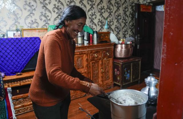 (251220) -- BURANG, Dec. 20, 2025 (Xinhua) -- Jamyang Drolma's mother cooks "Gutu" at their home in Khorchak Village, Burang County of Ngari Prefecture, southwest China's Xizang Autonomous Region, Dec. 18, 2025.
  Two days ahead of the Tibetan New Year is the traditional "Gutu Eve" for families to have a feast of "gutu", a traditional soup dish made of flour, at home. "Gu" in Tibetan means nine, which is a lucky number. "Tu" means "pasta." Nine different fillings like wool, charcoal and chili are placed inside the dough drops, and each of these fillings has a meaning. While in Burang, "Gutu" is a sort of porridge with nine ingredients and also a distinctive dish on the dinner table of the "Gutu Eve."
   In Khorchak Village of Burang County, Jamyang Drolma's family is bustling with New Year preparations at home. A pot of "Gutu" steams on the stove, while the "chema," a two-tier rectangular wooden box containing roasted barley and fried wheat grain, is placed to pray for harvest in the next year. This year, the family rejoiced over a bumper harvest of highland barley and peas. "Life is getting better and better, and our New Year celebrations are becoming more lively each year," Jamyang Drolma said with a smile. (Xinhua/Tenzin Nyida)