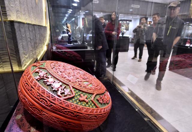 (251220) -- BEIJING, Dec. 20, 2025 (Xinhua) -- Visitors view a piece of carved lacquer work at an exhibition of intangible cultural heritages in Beijing, capital of China, Dec. 19, 2025.
  The exhibition showcases more than 500 pieces of artworks by inheritors of intangible cultural heritages nationwide. (Xinhua/Li Xin)