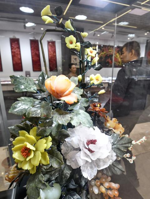 (251220) -- BEIJING, Dec. 20, 2025 (Xinhua) -- A visitor views a piece of jade carving work at an exhibition of intangible cultural heritages in Beijing, capital of China, Dec. 19, 2025.
  The exhibition showcases more than 500 pieces of artworks by inheritors of intangible cultural heritages nationwide. (Xinhua/Li Xin)