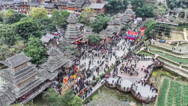 (251220) -- LIPING, Dec. 20, 2025 (Xinhua) -- An aerial drone photo taken on Dec. 20, 2025 shows tourists and people of Dong ethnic group celebrating the Dong New Year at Zhaoxing Dong village of Liping County, Qiandongnan Miao and Dong Autonomous Prefecture, southwest China's Guizhou Province. Dong New Year, a traditional festival for harvest and gathering, was enlisted as one of China's national intangible cultural heritages in 2011. Various activities were held in Liping County over the weekend. (Xinhua/Tao Liang)